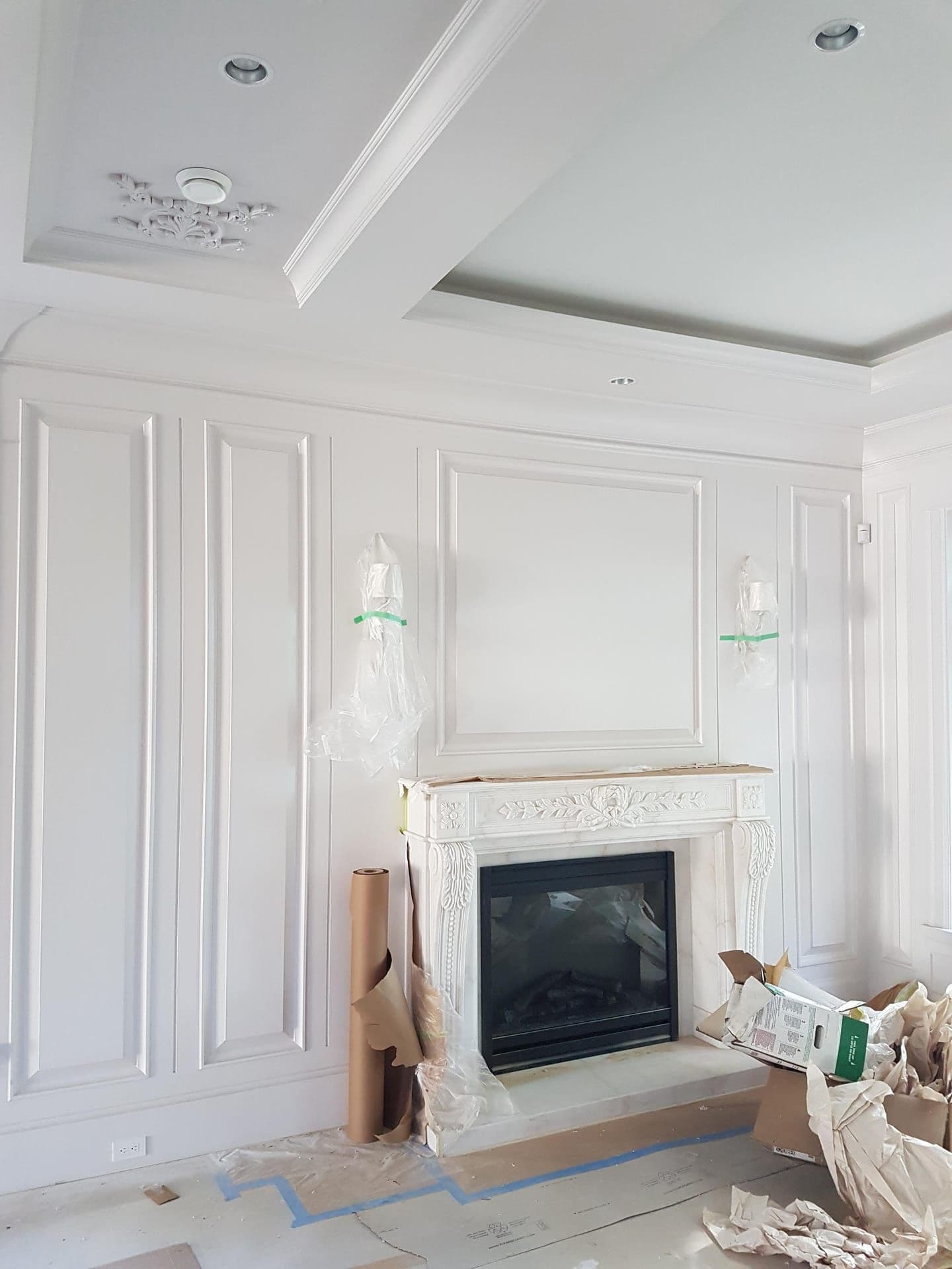 Living room with wainscoting, fireplace surround, and detailed trim
