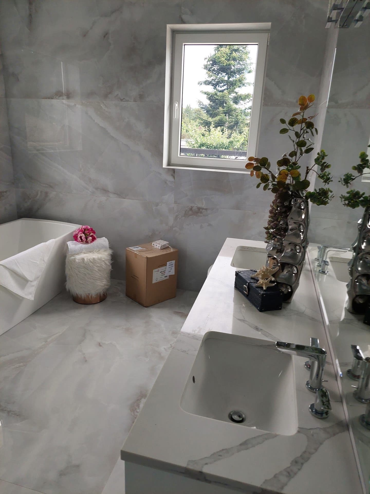 Marble bathroom with wall-mount faucet and floating vanity