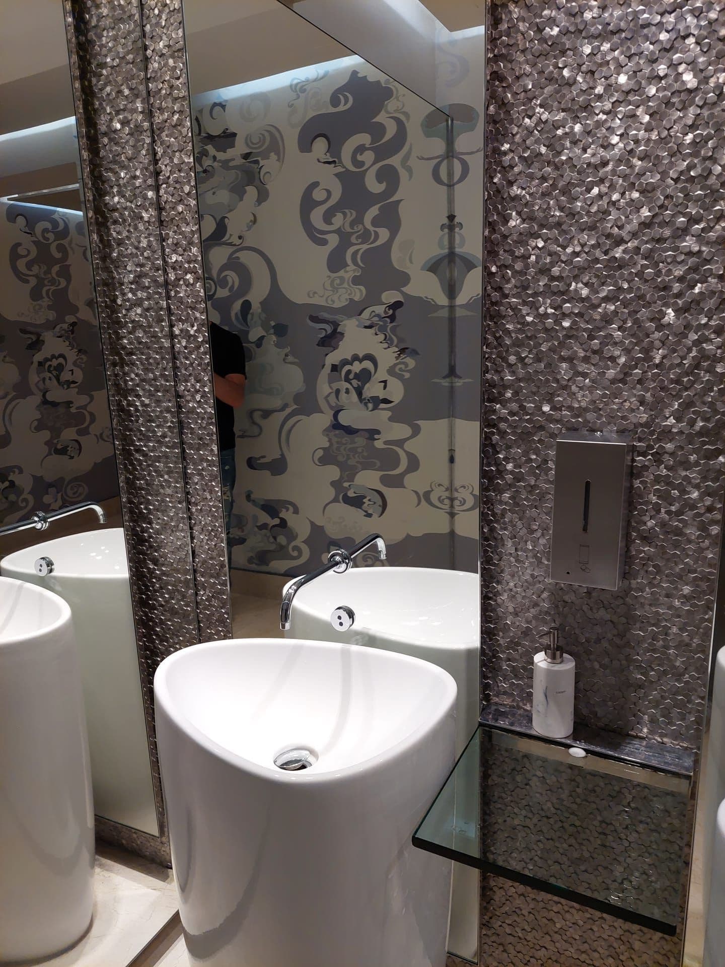Powder room with decorative mosaic tile and glass sink