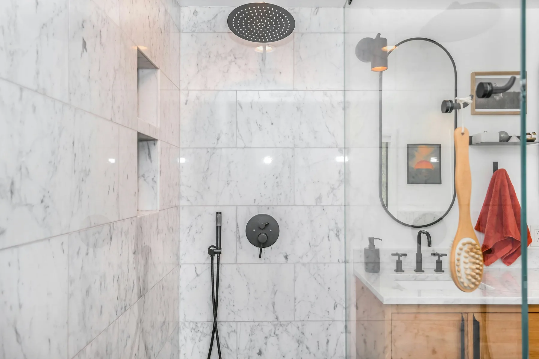 Marble tiled walk-in shower with recessed niches and matte black fixtures